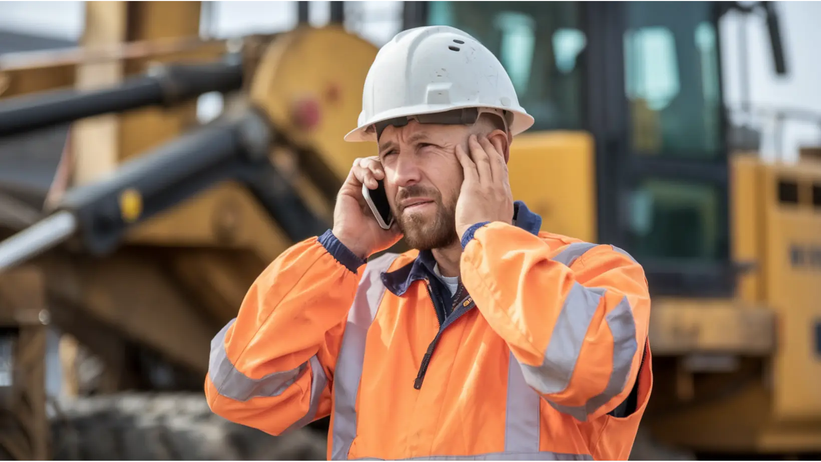 Construction worker who is hard of hearing speaking on mobile phone